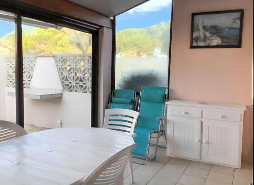 une terrasse couverte avec une table et des chaises et une vue sur l'eau dans l'établissement Maison charmante à Saint-Cyprien avec jardin et terrasse, à Saint-Cyprien