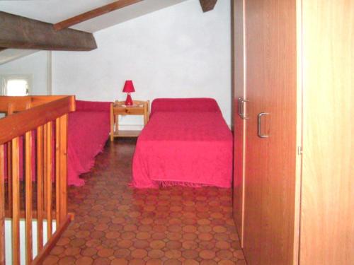 una camera con letto rosa e tavolo con lampada di Maison charmante à Saint-Cyprien avec jardin et terrasse a Saint-Cyprien