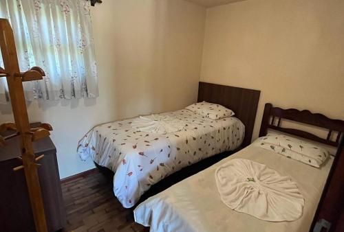 a bedroom with two beds and a window at Paraíso Enxaimel Mundo Antigo in Pomerode
