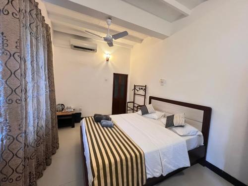 a bedroom with a bed with a striped bedspread at VillaWatuna in Unawatuna