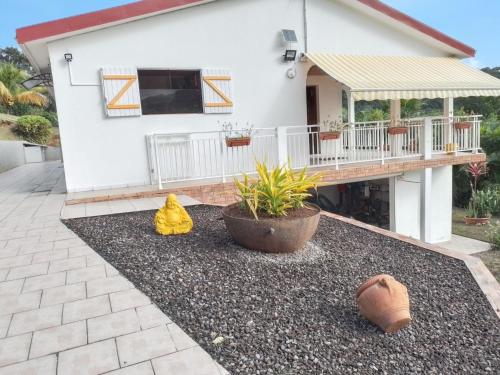 a house with a porch and a patio at Appartement cosy à La Trinité, 20 m², avec jardinlo in La Trinité