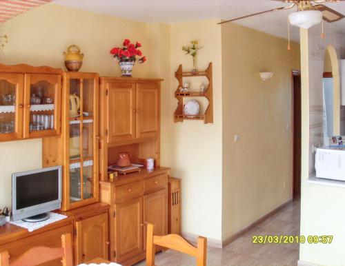 a living room with a television and wooden cabinets at Welcoming apartment in Mazarrón 56 m² with shared poolmo in Mazarrón