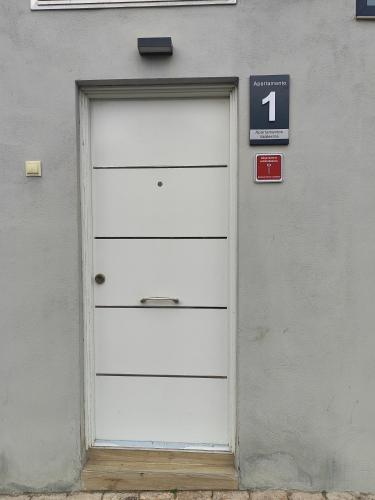 a white garage door with a sign next to it at Apartamentos VALDECILLA nuevos in Santander