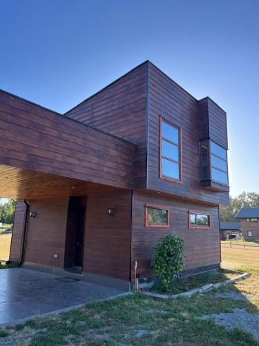 a large wooden house with a driveway at Cabaña en Condominio en Pucon in Pucón
