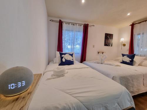 two beds in a room with red curtains at Pinilla Highlands Incredible mountain views in Tamarindo