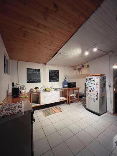 a kitchen with a refrigerator and a table in it at SURFHOUSE Pichilemu in Pichilemu