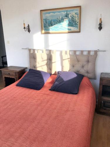 una camera da letto con un letto con copriletto arancione di Charmante maison à Arcangues avec vue sur les montagnesEL ad Arcangues