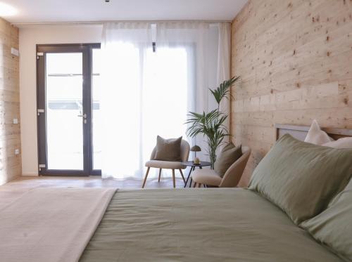 a bedroom with a bed and a large window at Suite Alpina, profumo di legno e relax totale in Maso