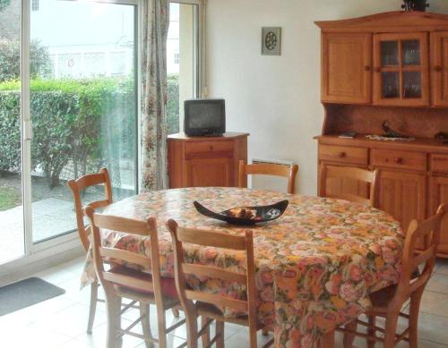 une salle à manger avec une table, des chaises et une télévision dans l'établissement Appartement moderne au Touquet-Paris-Plage, jardin clôturé, à Le Touquet-Paris-Plage