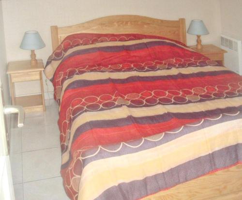 - une chambre dotée d'un lit avec une couverture rouge et brune dans l'établissement Appartement moderne au Touquet-Paris-Plage, jardin clôturé, à Le Touquet-Paris-Plage