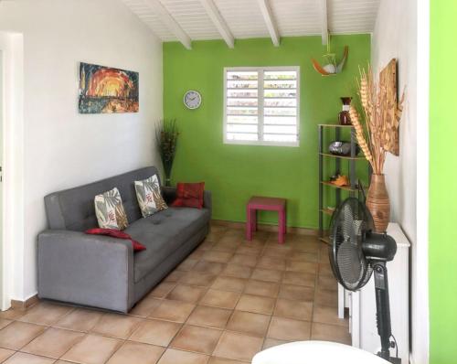 a living room with a couch and a fan at Appartement charmeur à Sainte-Anne, 40 m², jardin in Sainte-Anne