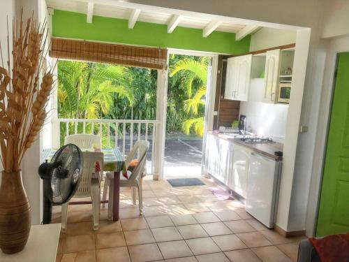 a kitchen with a table and a dining room with a patio at Appartement charmeur à Sainte-Anne, 40 m², jardin in Sainte-Anne