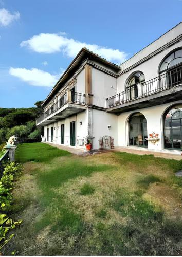 a large white house with a large yard at Spacious apartment with sea view in Massa Lubrense in Massa Lubrense