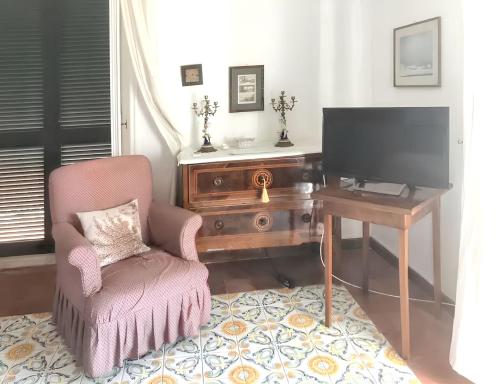 a living room with a desk and a chair and a television at Spacious apartment with sea view in Massa Lubrense in Massa Lubrense