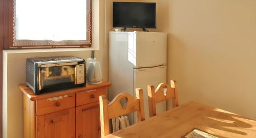 a kitchen with a microwave and a refrigerator at Appartement confortable avec vue sur la montagne in Notre-Dame-de-Bellecombe