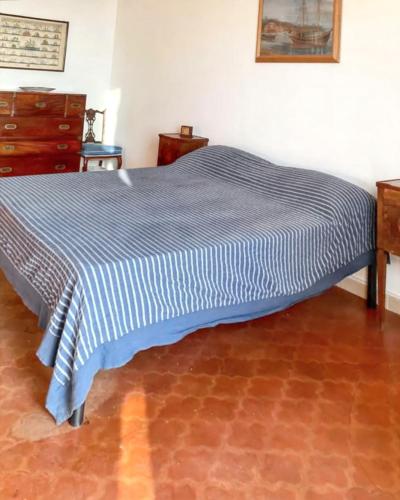 a bed in a room with a blue and white blanket at Spacious apartment with sea view in Massa Lubrense in Massa Lubrense