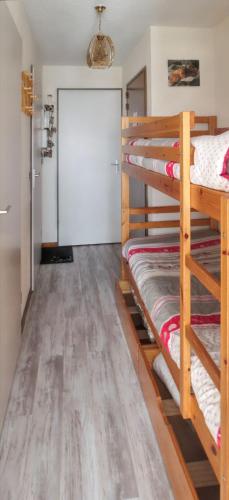 a room with three bunk beds and a door at Appartement confortable avec vue sur la montagne in Notre-Dame-de-Bellecombe