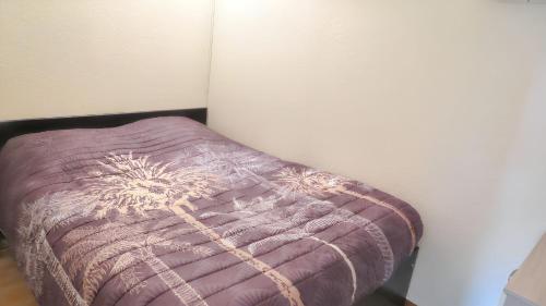 a purple pillow sitting next to a wall at Appartement confortable avec vue sur la montagne in Notre-Dame-de-Bellecombe