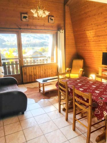 une salle à manger avec une table et des chaises et une fenêtre dans l'établissement Appartement cosy à Samoëns de 57 m² avec balcon., à Samoëns