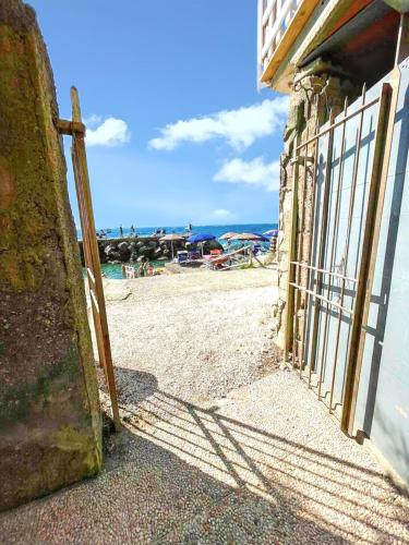 an open door to a beach with a fence at Spacious apartment with sea view in Massa Lubrense in Massa Lubrense