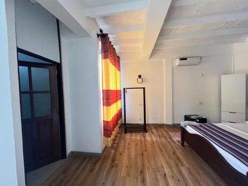 a bedroom with a bed and a colorful wall at VillaWatuna in Unawatuna