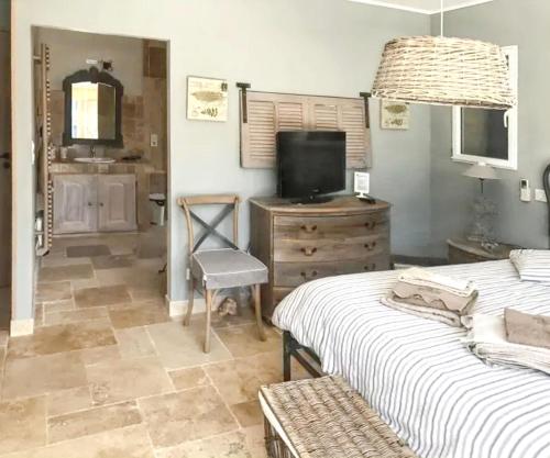 - une chambre avec 2 lits, une télévision et une commode dans l'établissement Villa élégante à Régusse avec piscine privée, à Régusse