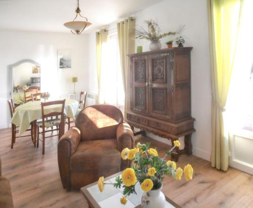 a living room with a couch and a chair and a table at Maison charmante à Portbail avec jardin et vue mer in Portbail