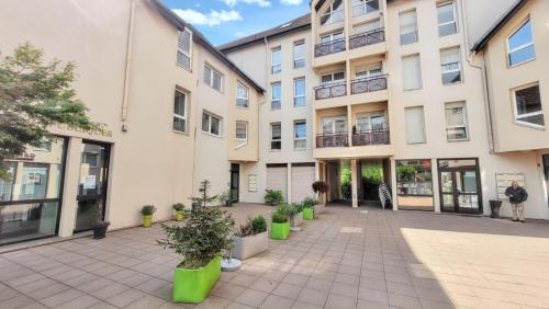 an empty courtyard in a building with potted plants at Appartement confortable à Bitche, 64 m², parfait pour familles in Bitche