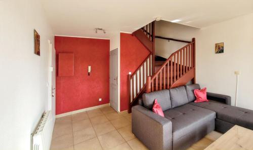 a living room with a couch and a red wall at Appartement confortable à Bitche, 64 m², parfait pour familles in Bitche