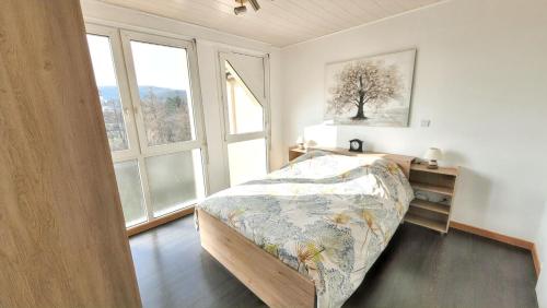 a bedroom with a bed and two windows at Appartement confortable à Bitche, 64 m², parfait pour familles in Bitche