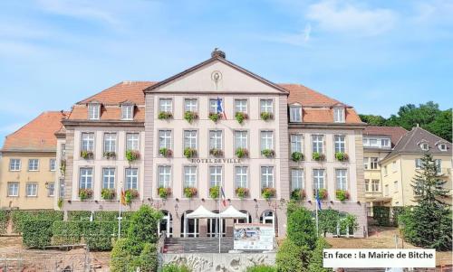 a large building with flowers on the front of it at Appartement confortable à Bitche, 64 m², parfait pour familles in Bitche