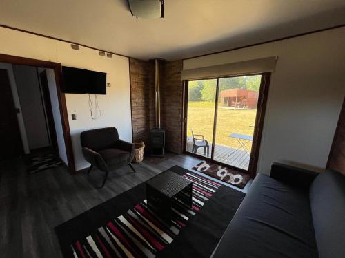 a living room with a couch and a sliding glass door at Cabaña en Condominio en Pucon in Pucón