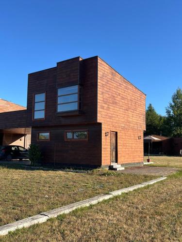 a large brick building with a yard in front of it at Cabaña en Condominio en Pucon in Pucón
