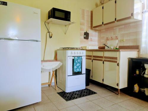 a kitchen with a white stove and a refrigerator at Fajardo Peaceful Place in Playa Sardinera