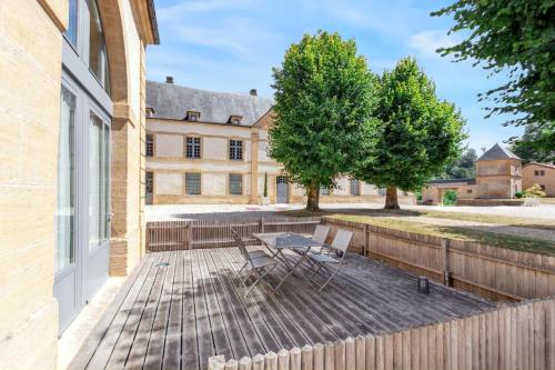 un patio avec une table et des chaises devant un bâtiment dans l'établissement Appartement spacieux à Cons-la-Grandville – 50 m² – TerrasseB, à Cons-la-Grandville