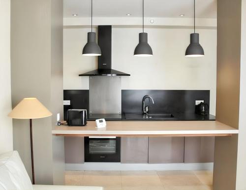 - une cuisine avec un comptoir, un évier et des lumières dans l'établissement Appartement spacieux à Cons-la-Grandville – 50 m² – TerrasseB, à Cons-la-Grandville