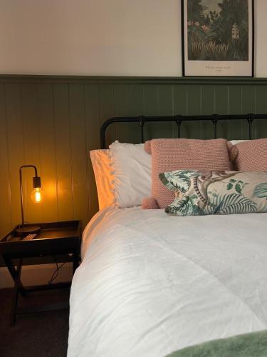 a bed with a green headboard and a side table at City Cottage in Lincoln