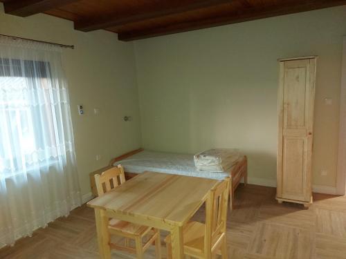 a room with a table and a bed and a window at Villa Padiego in Alojzów