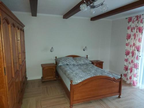 a bedroom with a bed and two wooden cabinets at Villa Padiego in Alojzów
