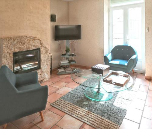 un salon avec deux chaises et une cheminée dans l'établissement Maison charmante à La Chapelle-Saint-Martin-en-Plaine avec jardin, à La Chapelle-Saint-Martin-en-Plaine