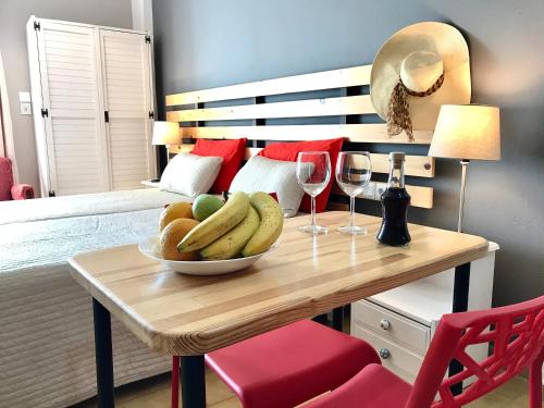a table with a bowl of fruit and two glasses of wine at Eleana Apartments in Hersonissos