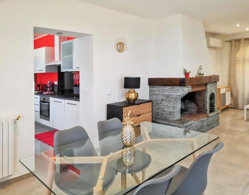 une salle à manger avec une table en verre et une cheminée dans l'établissement Appartement spacieux à Bastia avec vue mer et montagne., à Bastia