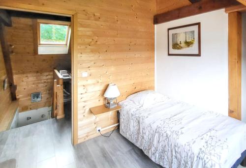 sypialnia z łóżkiem w drewnianym domku w obiekcie Maison de charme à Wuenheim avec jardin et terrasse w mieście Wuenheim