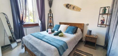 une chambre avec un grand lit avec des oreillers bleus dans l'établissement Charmant appartement à Carcassonne avec vue sur le jardin - 35m², à Carcassonne