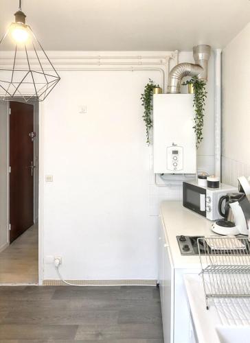 - une cuisine avec des murs blancs et une cuisinière four supérieur dans l'établissement Studio confortable proche Disneyland Paris, 34 m², balcon, à Thorigny-sur-Marne