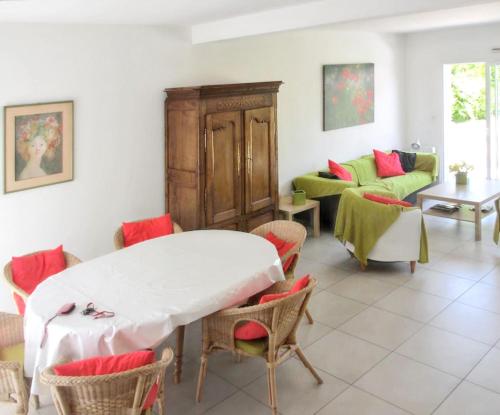 un salon avec une table et des chaises dans l'établissement Maison charmante à Perros-Guirec avec terrasse et jardin, à Perros-Guirec