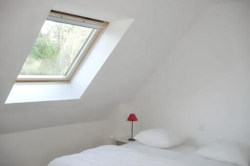 une chambre avec un lit et une fenêtre dans l'établissement Maison charmante à Perros-Guirec avec terrasse et jardin, à Perros-Guirec