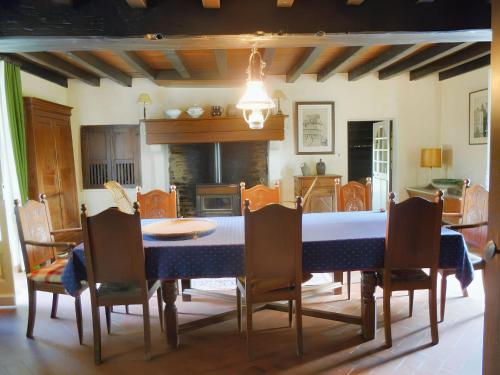 une salle à manger avec une table et des chaises bleues dans l'établissement Maison chaleureuse à Terres-de-Haute-Charente avec jardin, à Saint-Germain-et-Mons