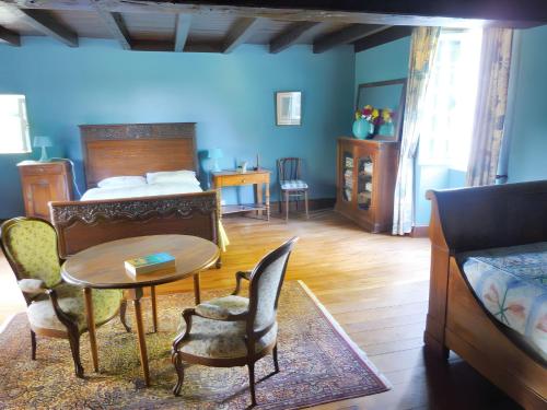 une chambre avec un lit, une table et des chaises dans l'établissement Maison chaleureuse à Terres-de-Haute-Charente avec jardin, à Saint-Germain-et-Mons