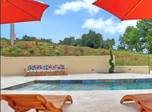 - une piscine avec un parasol rouge et des bancs dans l'établissement Villa charmante à Divajeu avec piscine privée, à Divajeu